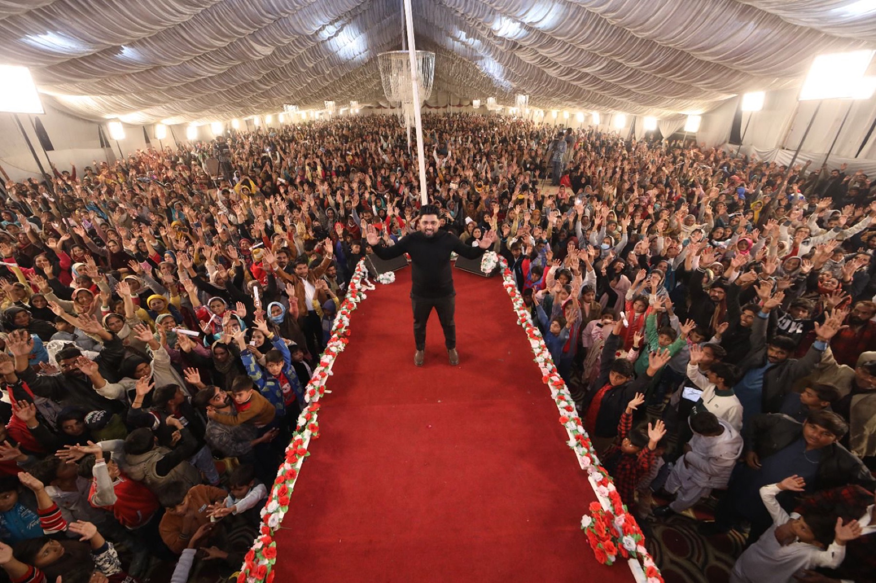 Thousands worship with raised hands under the Exodus51 tent church