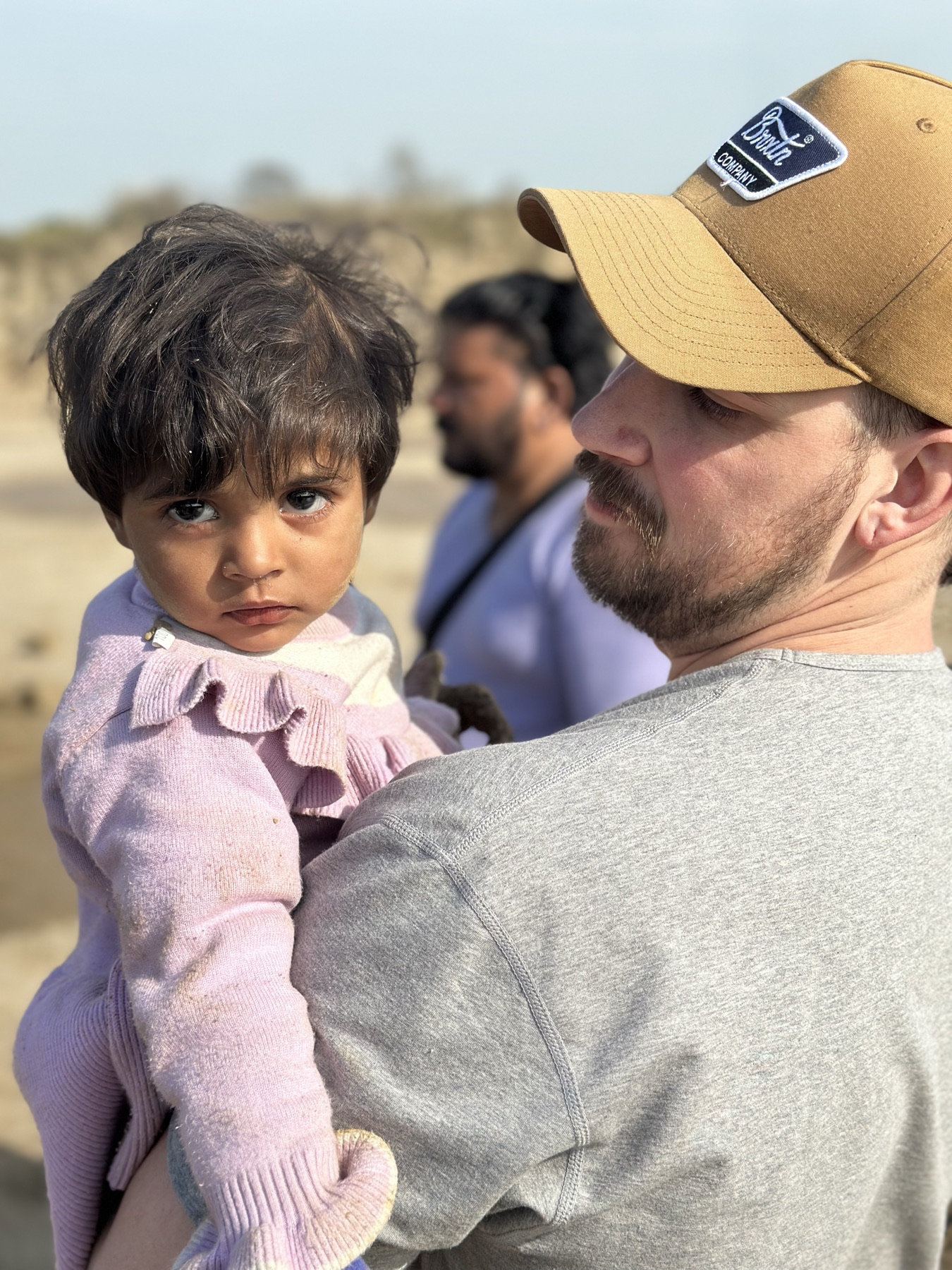 A pastor partner carries a newly freed girl at a brick kiln