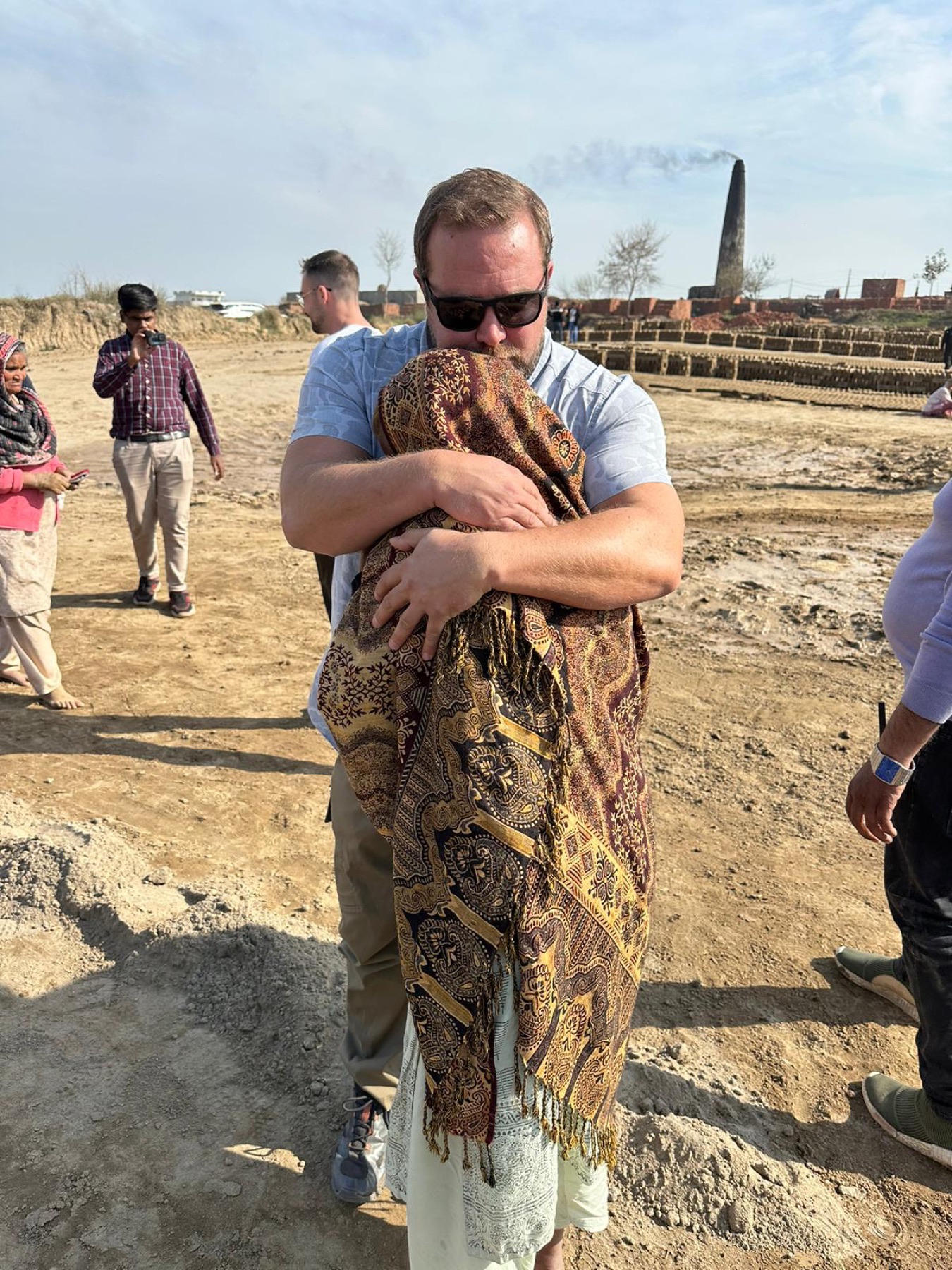An Exodus51 team member embraces a newly freed person wrapped in a blanket