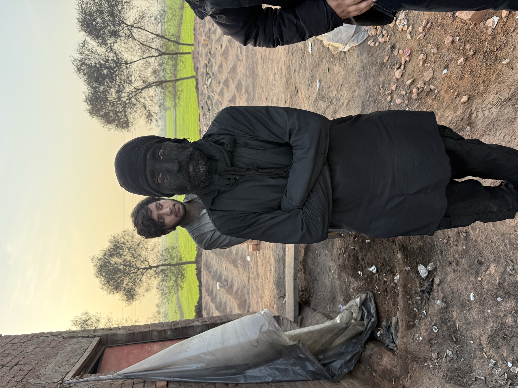 A kiln worker covered head to toe in black soot
