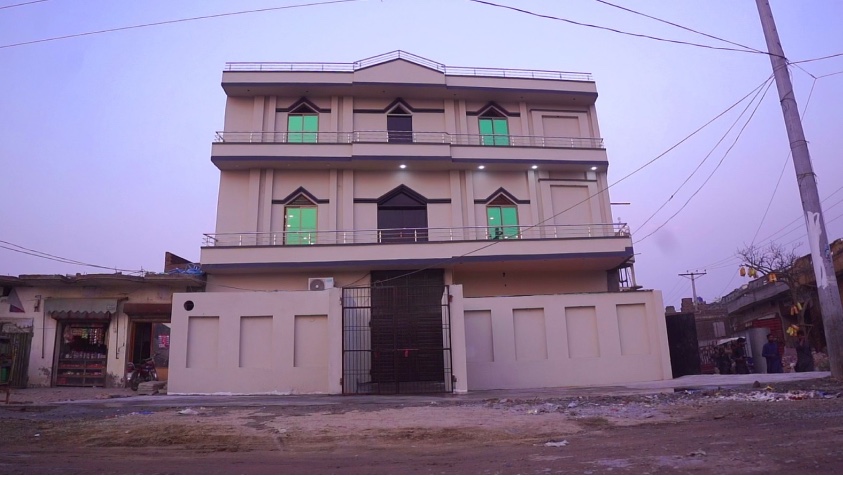 The finished three-story school and church building at dusk